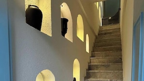 Un escalier avec des marches et des murs en pierre, agrémenté d’ouvertures en arc de cercle.