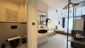 Une salle de bain moderne avec un grand lavabo, des toilettes et un espace douche.