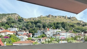 Un quartier résidentiel avec des maisons construites sur une colline, un panneau avec du texte, et un ciel dégagé.