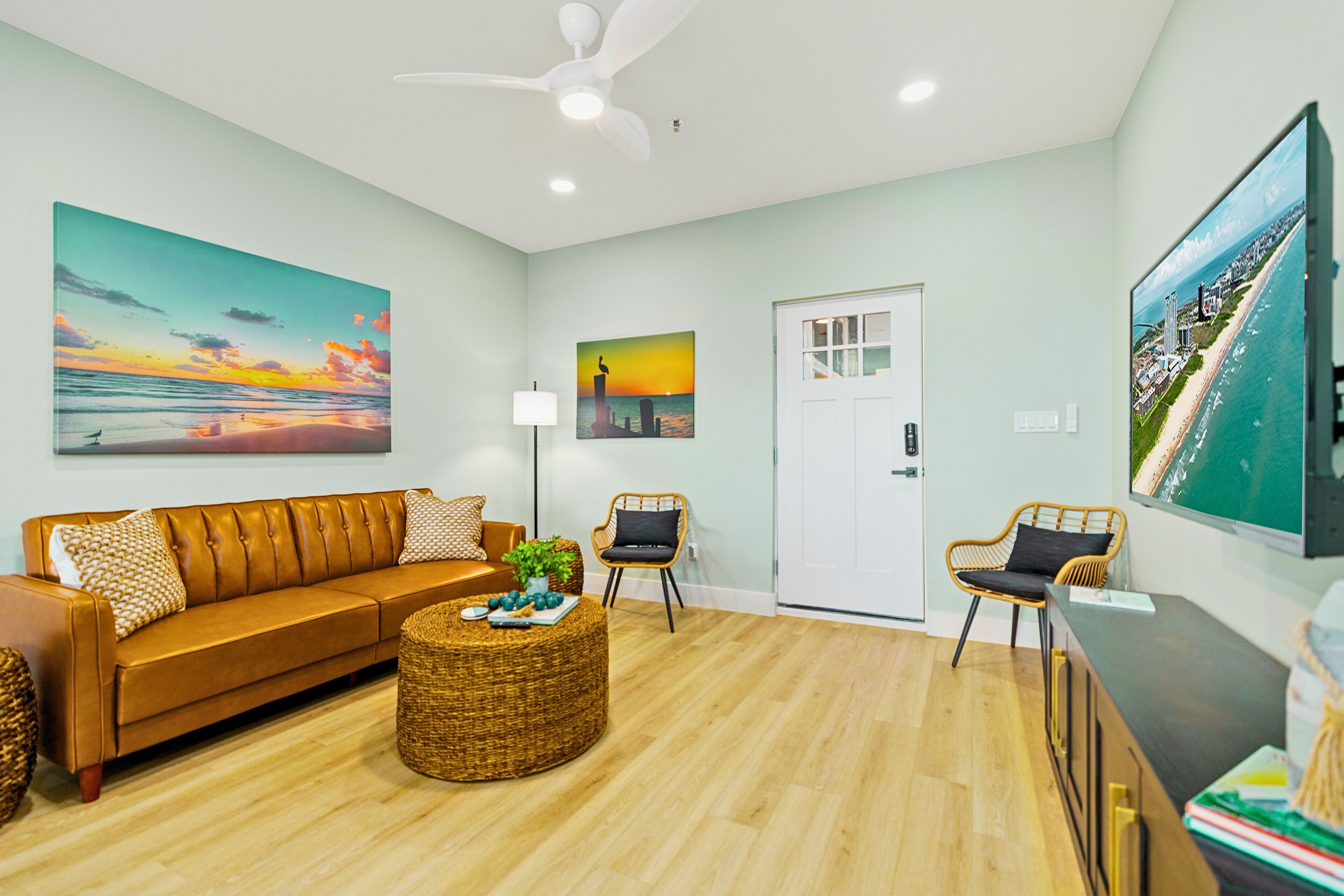 A modern living room with a sofa, chairs, a coffee table, and artwork on the walls.