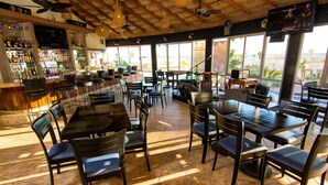 Ein Restaurant mit Außenbereich, einer Bar und großen Fenstern mit Blick.