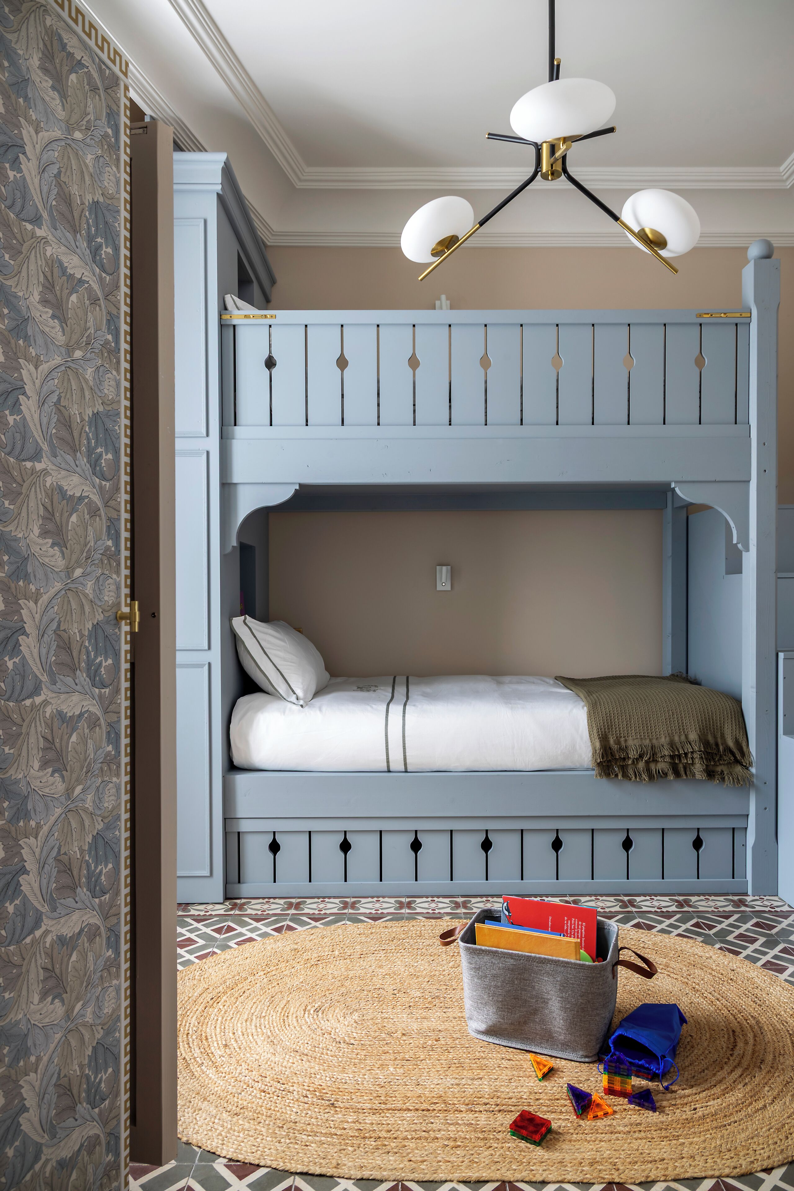 A room with a bunk bed, a woven rug, and a storage basket.