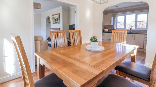 A dining area with a wooden table, four chairs, and a potted plant. - Thorntons House (Northallerton)