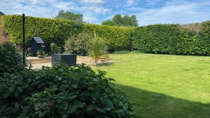 A well-maintained garden with a lawn, a birdhouse, and a small shed. - Thorntons House (Northallerton)