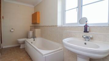 A bathroom with a bathtub, toilet, and sink.