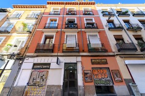 A multi-story building with balconies, a shop on the ground floor, and a sign indicating a chocolate shop. - M Esa80e Piso en el Centro de Madrid - Malasa a (Madrid)