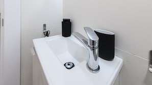 A modern bathroom with a white sink, chrome faucet, and black containers. - M Piz401 Acogedor Estudio en el Centro de Madrid (Madrid)