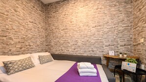A neatly made bed with a purple bedspread, two patterned pillows, and a sign for rentals. - M Jpa16bi Acogedor Piso 1 Dormitorio en Tetu n (Madrid)