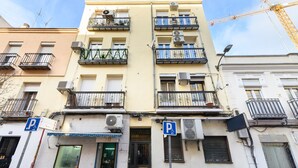 A multi-story building with balconies, air conditioning units, and a visible storefront. - M Jpa16bi Acogedor Piso 1 Dormitorio en Tetu n (Madrid)
