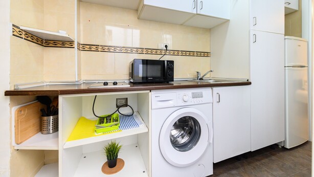 A compact kitchen with a microwave, washing machine, and a small countertop area. - M Jpa16bi Acogedor Piso 1 Dormitorio en Tetu n (Madrid)