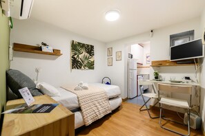 A compact hotel room with a bed, a desk, a chair, a TV, and a small kitchenette. - M Svf1304 Acogedor Estudio en Centro de Madrid (Madrid)