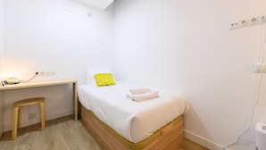 A small, neatly arranged bedroom with a single bed, a wooden desk, and a stool. - M Fga50e Acogedor d Plex en Chamber (Madrid)