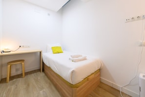 A small, neatly arranged bedroom with a single bed, a wooden desk, and a stool. - M Fga50e Acogedor d Plex en Chamber (Madrid)