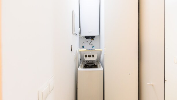 A compact, white utility room with a water heater, a small sink, and a door. - M Fga50e Acogedor d Plex en Chamber (Madrid)