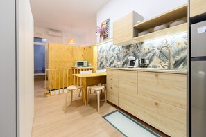 Eine kleine Küche mit Holzausstattung, einer eingebauten Mikrowelle und einem Spülbecken.