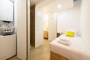 Ein modernes Hotelzimmer mit Bett, Badezimmer und einer Minibar.