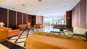 A spacious lobby with a checkered floor, multiple sofas, and a wooden reception desk. - M Mle16a2320 Amplio Piso 1 Dormitorio en Chamart (Madrid)