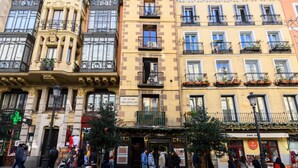 A row of multi-story buildings with balconies, a street with pedestrians, and storefronts. - M May613 Piso de 1 Dormitorio en Pleno Centro de (Madrid)