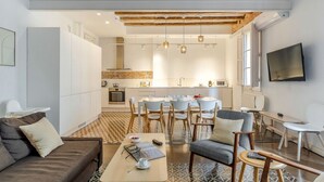 Uma sala de estar moderna com sofá, mesa de centro e área de refeições.