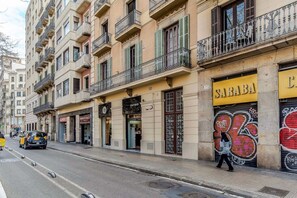 A street with buildings, a person walking, and a car. - Modern 6-Bedrooms Flat / Plaza Cataluña, Ramblas (08007 Barcelona)