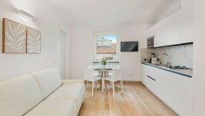 Un espacio habitable pequeño con sofá, mesa de comedor y cocina.