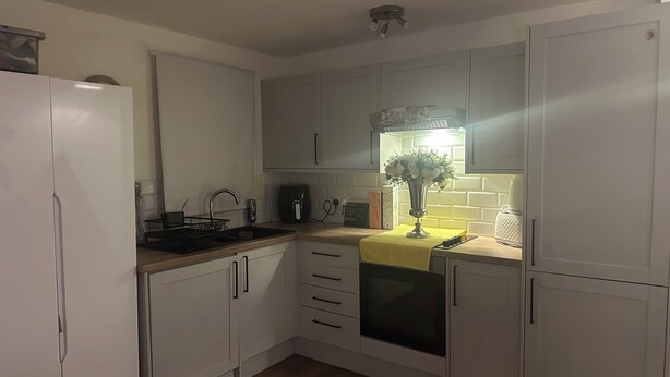 A modern kitchen with white cabinets, a stainless steel sink, and a built-in oven. - Spacious studio flat in London (London)