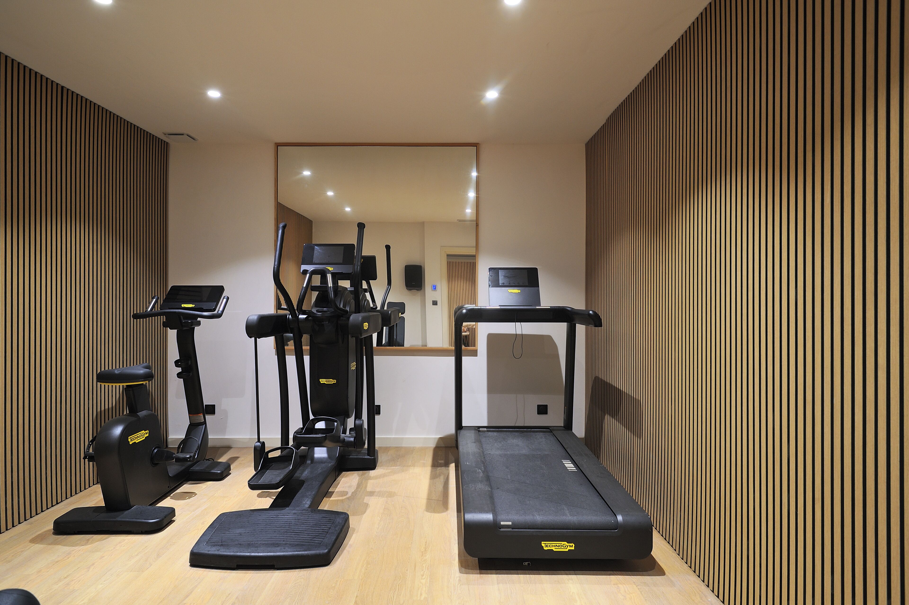 A gym with treadmills, elliptical machines, and a stationary bike.