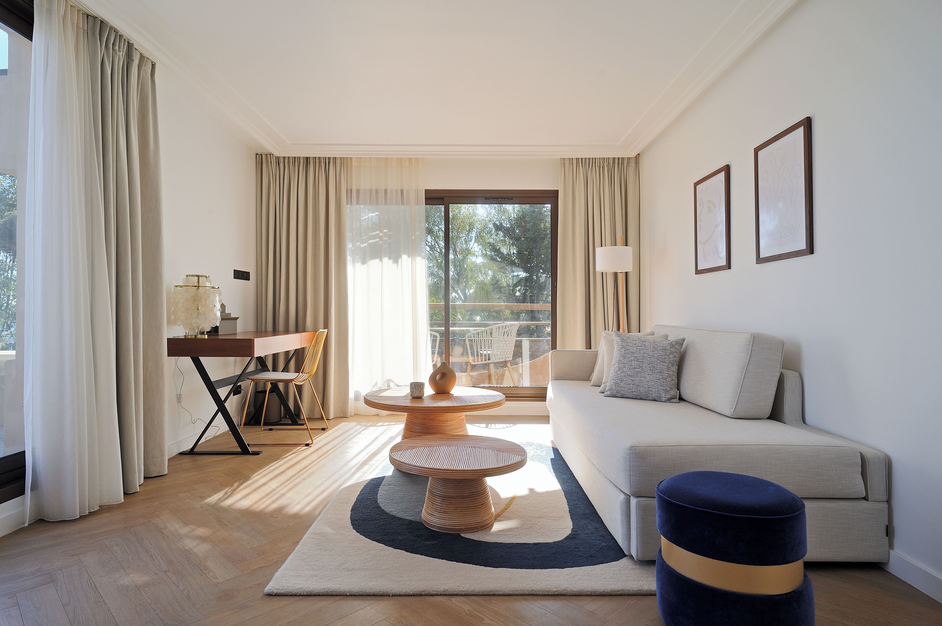Una sala de estar moderna con un sofá, una mesa de centro redonda y vistas al exterior.