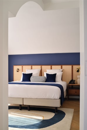 Une chambre à coucher moderne avec un lit, des tables de chevet et une commode.