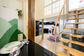 A modern kitchen with a central island, a staircase with wooden steps, and a view of the living area. - M Hor291 Moderno d Plex de 1 Dormitorio con Toda (Madrid)