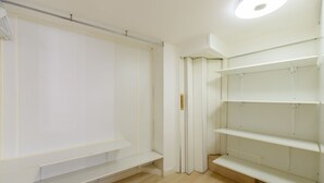 A room with a white wardrobe, a white shelf unit, and a wooden floor. - M Hor291 Moderno d Plex de 1 Dormitorio con Toda (Madrid)