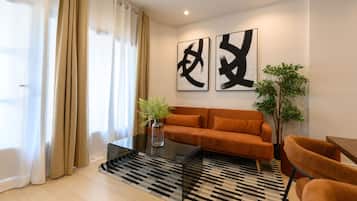 A modern living room with a sofa, a coffee table, and a plant.