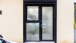 A black-framed door with a glass panel, a small sign above it, and a building number '3' on the wall. - M Rjs3 Acogedor Estudio en Barrio Salamanca (Madrid)