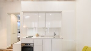 A modern kitchen with white cabinetry, a built-in oven, and a sink. - M Hor42da Estudio Moderno en el Centro de Madrid (Madrid)