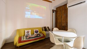 A room with a yellow sofa, a white table with chairs, and a wooden door. - M Hor42da Estudio Moderno en el Centro de Madrid (Madrid)