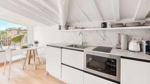 Una cocina moderna con armarios blancos, horno empotrado y ventana con vistas a la ciudad.
