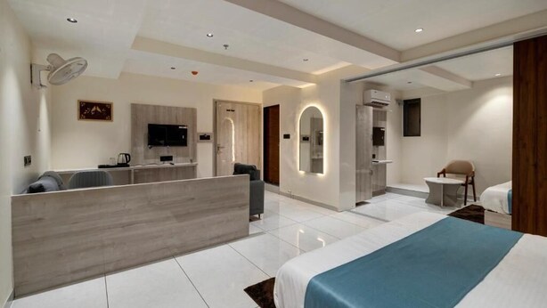 Une chambre d’hôtel moderne dotée d’un grand lit, d’un bureau, d’un coin salon et d’une salle de bain.