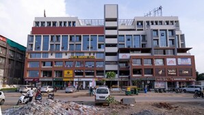 Un hôtel à plusieurs étages, reconnaissable à son enseigne bien visible indiquant « Hôtel Shrimad Villa ».