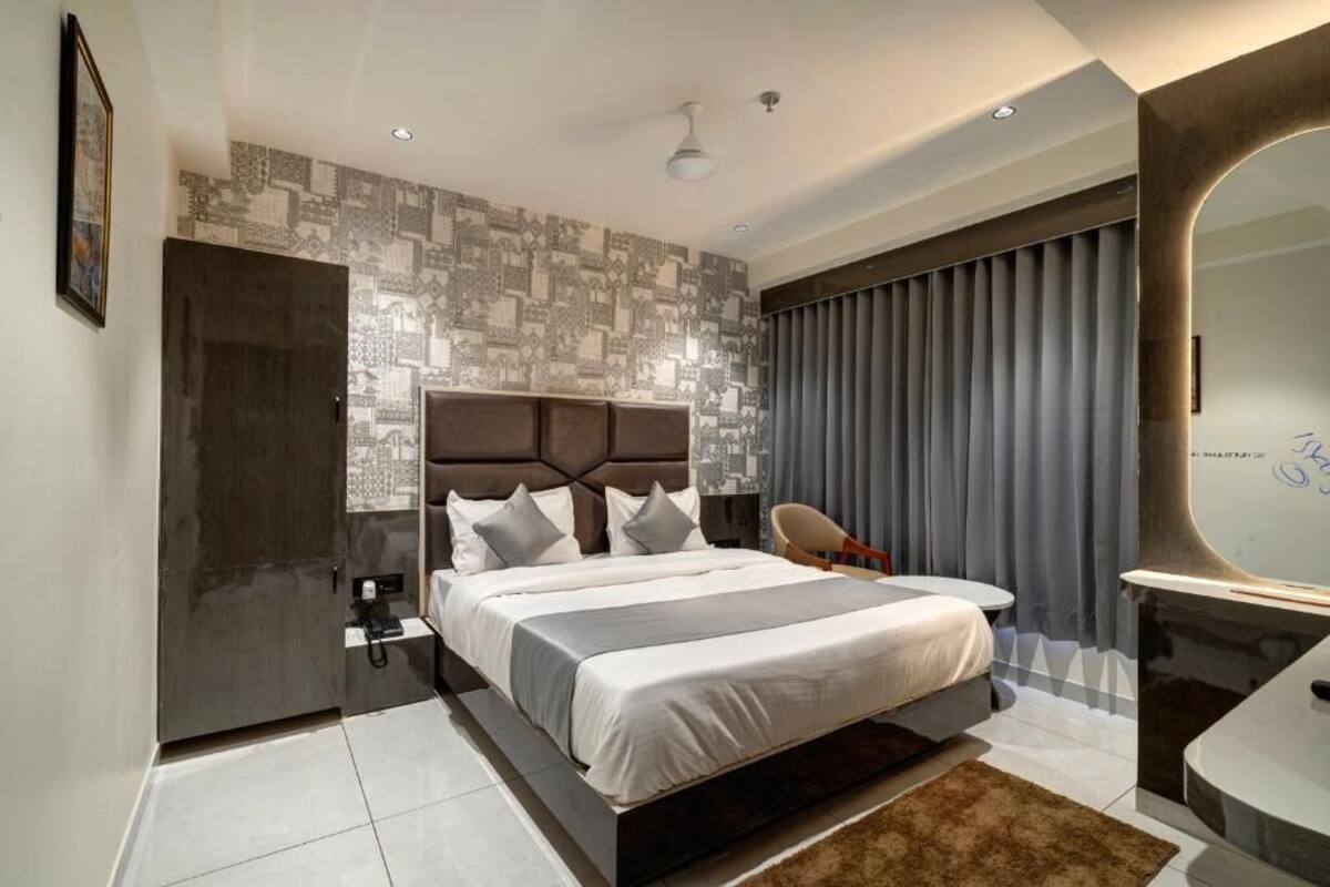 Une chambre moderne avec un grand lit, un bureau intégré et un grand miroir.