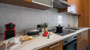 A kitchen with a countertop, a toaster, a pot, a cutting board, and some vegetables. - Italianway - Boncompagni 2 (Milan)