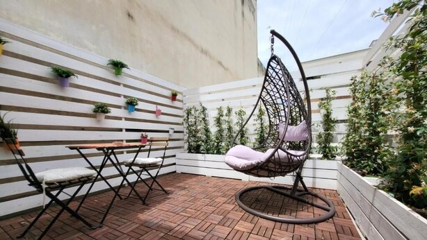 A patio with a hanging chair, a table, and chairs. - The Attico (Bari)