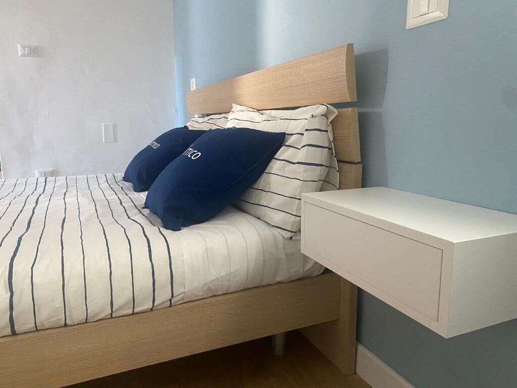 Un lit avec une literie à rayures, une tête de lit et deux oreillers.