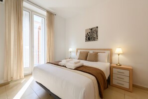 A neatly made bed with a brown throw blanket, two bedside lamps, and a zebra artwork on the wall. - 2-Bedroom Apartment Steps Away from Gran Vía: Live in the Heart of Madrid (Madrid)