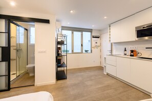 A modern kitchen with white cabinets, a built-in oven, and a coffee machine. - (TES314E) Cozy Studio in the Center of Madrid (Madrid)