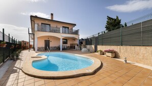 Une maison à deux étages dotée d’une piscine, d’un balcon et d’une terrasse clôturée.