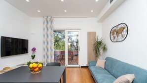 A modern living room with a dining table, a sofa, a TV, and a world map wall decoration. - YourHome - Lady Lucy Holiday Home (Meta)