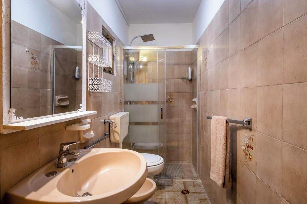 Un baño con lavamanos grande, inodoro y cabina de ducha.