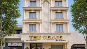 Un edificio de varios pisos con un cartel llamativo que dice 'THE VENUE'.