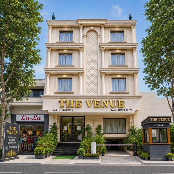Un edificio de varios pisos con un cartel llamativo que dice 'THE VENUE'.