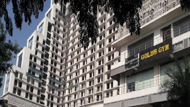 A multi-story hotel with a modern design, featuring a prominent gym on the ground floor. - Khatu Hotel (Greater Noida)